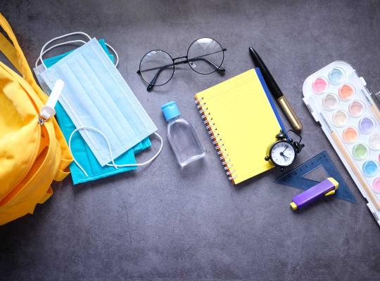 studentenschooltaspakket met ontsmettingsmiddel en een mondmasker